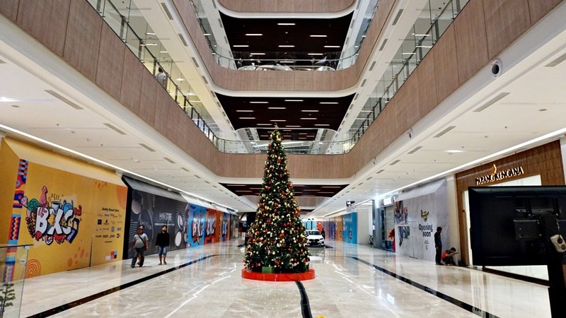 Atrium mal dengan pohon natal di tengah-tengah.