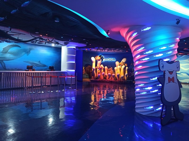 Lobby ruang permainan anak dengan cahaya warna-warni bertema laut.