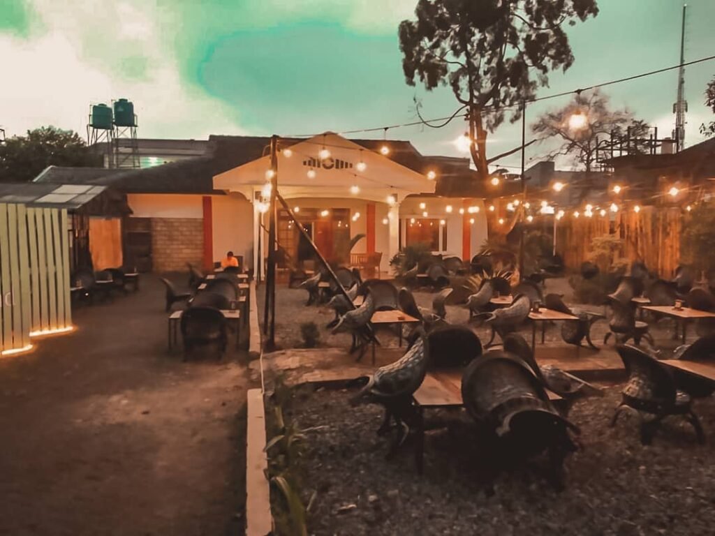 Cafe di ruang terbuka dengan suasana taman belakang rumah.