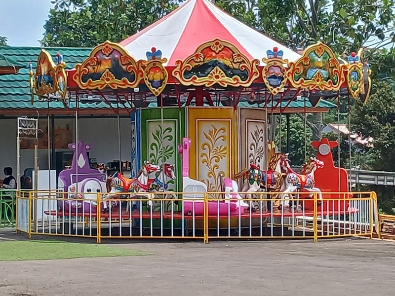 Komedi putar berukuran kecil di taman bermain anak.